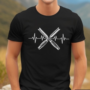 May include: Black t-shirt featuring a white graphic of crossed wood chisels with a heartbeat line. The shirt has a crew neck and short sleeves. The word "BLACK" is in a white font inside a black rectangle.
