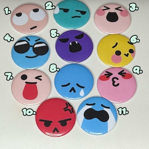 May include: Eleven round emoji pin badges in various colours. Each badge features a different facial expression, including happy, sad, angry, and surprised. The badges are numbered 1 to 11.
