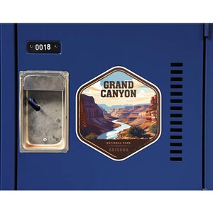 May include: A hexagonal sticker featuring a graphic illustration of the Grand Canyon with a winding river, layered rock formations, and the text GRAND CANYON NATIONAL PARK ARIZONA, applied to a blue metal locker door with the number 0018.