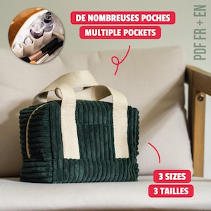 Puede incluir: Un neceser de pana verde oscuro con asas color crema y cierre de cremallera. La bolsa es rectangular y se encuentra sobre una superficie beige. El texto en la imagen dice "Multiple Pockets" y "3 Sizes".