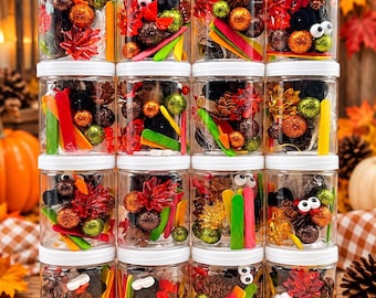 May include: A collection of sixteen clear plastic jars with white lids, each filled with a craft kit containing small pinecones, glittery orange and green spheres, colorful wooden sticks, googly eyes, and artificial autumn leaves.