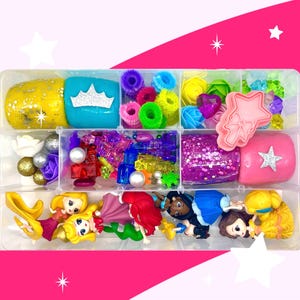 May include: A clear plastic storage box filled with colorful craft supplies, including princess figurines, glitter slime, hair ties, and small plastic jewels. The box is perfect for creative play and imaginative fun.