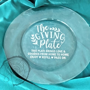 Pode incluir: Um prato de serviço de vidro transparente com o texto "The Giving Plate" e as palavras "This plate brings love & goodies from home to home. Enjoy Refill Pass On".