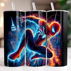 May include: A set of three black insulated tumblers featuring a vibrant illustration of Spider-Man in action. The design showcases the superhero against a glowing cityscape with blue and orange hues, complete with a straw.