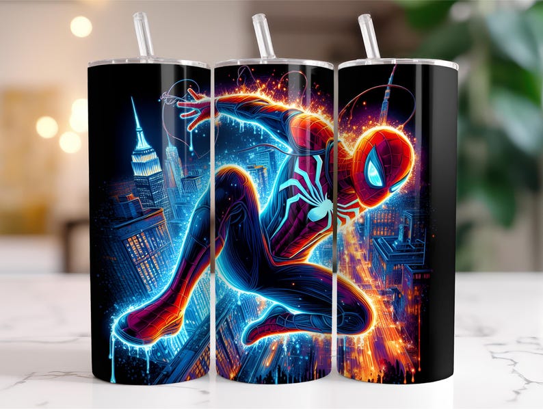 May include: A set of three black insulated tumblers featuring a vibrant illustration of Spider-Man in action. The design showcases the superhero against a glowing cityscape with blue and orange hues, complete with a straw.