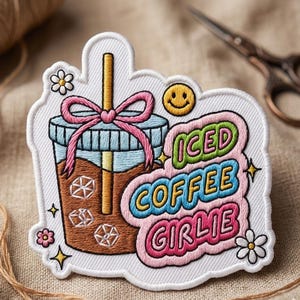 May include: Embroidered patch featuring an iced coffee drink with a pink bow and straw. The patch includes the text "ICED COFFEE GIRLIE" in colorful lettering, along with a smiley face and floral accents.