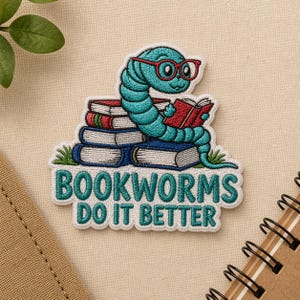 May include: Embroidered patch featuring a teal bookworm wearing red glasses and reading a red book atop a stack of books. The patch reads "BOOKWORMS DO IT BETTER" in teal lettering with a white border. The patch is on a beige background.