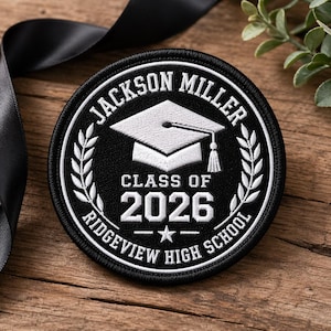 May include: A black and white embroidered patch with the text "JACKSON MILLER", "CLASS OF 2026", and "RIDGEVIEW HIGH SCHOOL". The patch features a graduation cap and laurel wreath design.