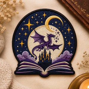 May include: Embroidered patch featuring a purple dragon soaring in front of a full moon and a starry night sky. A castle sits atop an open book, with purple clouds below. The patch has a navy blue border and gold accents.