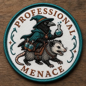 Könnte beinhalten: Runder, gestickter Aufnäher mit türkisfarbenem Rand und dem Schriftzug "PROFESSIONAL MENACE". Der Aufnäher zeigt eine Krähe mit Zaubererhut, die auf einem Opossum reitet und einen Trank und Flaschen trägt.