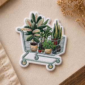 Peut inclure: Écusson brodé représentant un chariot de magasinage rempli de plantes en pot. Les plantes ont des feuilles vertes et roses, dans des pots en céramique et tressés. Le chariot est bordé de blanc et de vert, avec des roues jaunes.