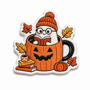 May include: An embroidered patch featuring a white ghost wearing an orange beanie and round glasses, reading a book inside an orange pumpkin-shaped mug. The design includes a stack of books, a small polka-dot mug, and scattered orange maple leaves.