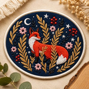 May include: Embroidered patch with a red fox, white chest and tail, set against a navy blue background. The design includes gold and green foliage, pink flowers, stars, berries, and a crescent moon. The patch has a white border.