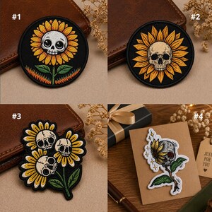 May include: Four patches with a sunflower and skull design. The patches are round and feature a black background with yellow and orange sunflower petals. One patch has a stem and leaves.