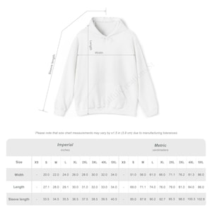 Puede incluir: Sudadera con capucha blanca con bolsillo delantero, que muestra medidas de ancho, largo y largo de manga en cent&iacute;metros. La tabla de tallas incluye medidas de XS a 5XL. El texto en la parte inferior dice: "Tenga en cuenta que las medidas de la tabla de tallas pueden variar en &plusmn;1,5 pulgadas (3,8 cm)".