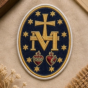 May include: An embroidered patch with a navy blue oval background, featuring a gold cross and the letter "M". Gold stars surround the central design. Two red hearts with flames are at the bottom. The patch is trimmed with gold and white stitching.