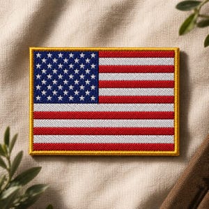 May include: Embroidered patch featuring the American flag. The patch has a blue field with white stars in the upper left corner and red and white stripes. The patch is rectangular with a gold border.