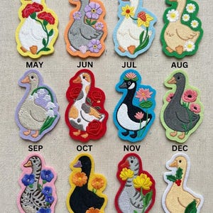 May include: Embroidered patches featuring geese, each representing a month of the year. The patches are in various colors, with floral accents and the month's name above. A fun, decorative item.