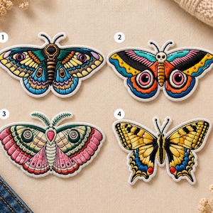 May include: Four embroidered butterfly patches with intricate designs and vibrant colors. Each patch features a unique butterfly with detailed wings, including shades of blue, yellow, pink, and black. The patches are outlined with white stitching.