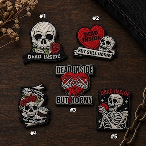 May include: Embroidered patches with skull designs. One patch features a skull with a rose and the text "DEAD INSIDE." Other patches include phrases like "BUT STILL HORNY" and "BUT HORNY." The patches are black with white, red, and green accents.
