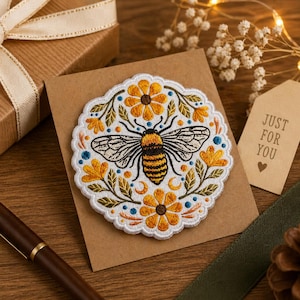 May include: Embroidered patch featuring a detailed bee design with yellow and black stripes, surrounded by yellow flowers, blue accents, and green leaves. The patch is on a brown card with a "JUST FOR YOU" tag. The patch is approximately 4 inches in diameter.
