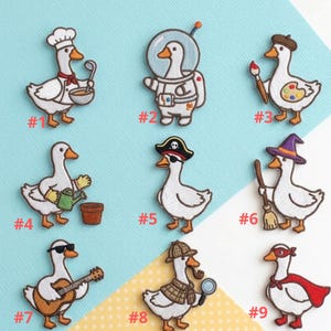 May include: A collection of nine embroidered patches featuring white geese in various professions and costumes. The geese are depicted as a chef, astronaut, artist, gardener, pirate, witch, musician, detective, and superhero. Each patch has a number.
