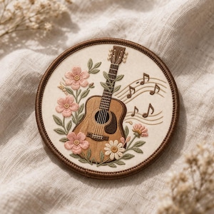 May include: Embroidered patch featuring a brown acoustic guitar with floral accents and musical notes. The guitar is surrounded by pink and white flowers and green leaves, set against a cream-colored background within a brown circular frame.