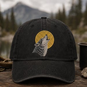 May include: Black baseball cap with an embroidered design of a howling wolf in front of a yellow circle. The wolf is gray and white, and the cap is made of a soft, durable material. The cap is a classic, casual style.