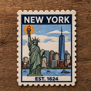May include: A rectangular embroidered patch shaped like a postage stamp featuring the Statue of Liberty and the New York City skyline. The text NEW YORK appears at the top and EST. 1624 at the bottom. The design includes blue, green, and white.