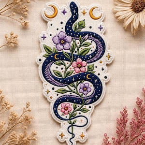 May include: Embroidered patch featuring a stylized blue snake with a starry pattern, intertwined with flowering vines. The design includes purple and pink flowers, crescent moons, and stars, all set against a white background.
