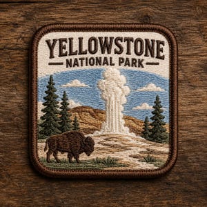 May include: Embroidered patch featuring the text "YELLOWSTONE NATIONAL PARK" above a landscape scene. The scene includes a geyser erupting, a bison, pine trees, and a blue sky with clouds. The patch has a brown border.