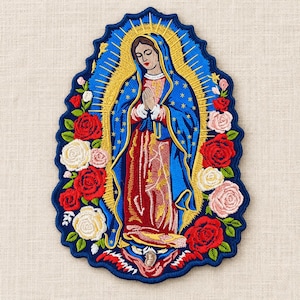May include: An embroidered patch featuring the Virgin of Guadalupe with a blue mantle, red dress, and gold rays. The figure is surrounded by red, white, and pink roses with green leaves, all set against a dark blue scalloped border.
