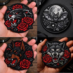 May include: Set of four embroidered patches featuring animal designs. Includes a black panther with red roses, a bat with a full moon, a Doberman Pinscher, and a wolf with red roses. Each patch is round with a black border.