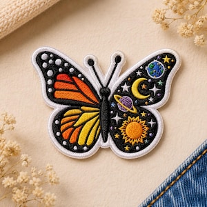 May include: Embroidered butterfly patch with a celestial design. One wing features orange and yellow patterns, while the other showcases a night sky with stars, a crescent moon, and planets. The patch has a white border.