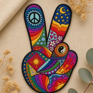 May include: A colourful embroidered peace sign patch. The design includes a peace symbol, stars, a crescent moon, a sun, and a yin-yang symbol, all in a rainbow of colours. The patch is outlined in black.