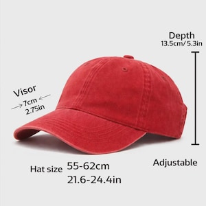 May include: A red adjustable baseball cap with a visor measuring 2.75 inches. The hat depth is 5.3 inches, and the hat size is 21.6-24.4 inches. The cap is made of a soft material and has a curved brim.