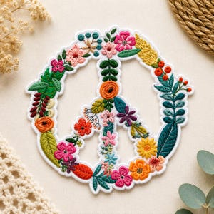 May include: Embroidered peace sign patch featuring a colorful floral design. The patch is outlined in white and filled with various flowers and leaves in shades of pink, orange, green, and yellow.