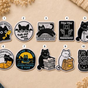 May include: A collection of ten embroidered patches featuring cat designs. The patches include phrases like "I choose violence," "Working from home," and "Life is better with." Each patch has a unique cat illustration.