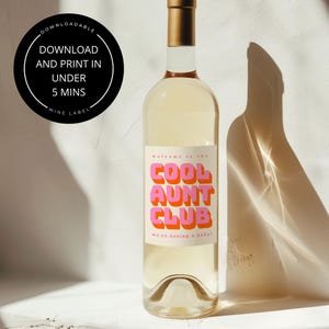 以下が含まれることがあります： 金色のキャップが付いた透明なワインボトル。ラベルには「Welcome to the COOL AUNT CLUB, we're having a baby!」と書かれています。白い文字で「DOWNLOADABLE, DOWNLOAD AND PRINT IN UNDER 5 MINS, WINE LABEL」と書かれた黒い円。