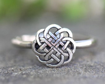 May include: A silver ring with a Celtic knot design. The knot is intricate and detailed, and the ring is simple and elegant.