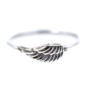 May include: A silver ring with a wing design. The wing is detailed and has a textured finish.