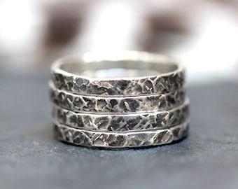 May include: A set of four silver stacking rings with a hammered texture.