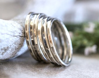 Könnte beinhalten: Ein Satz von fünf silbernen, gehämmerten Stapelringen. Die Ringe sind alle unterschiedlich groß und werden übereinander gestapelt.