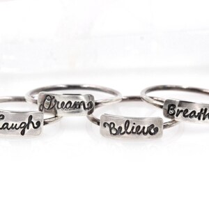 以下が含まれることがあります： 「Laugh」、「Dream」、「Believe」、「Breathe」という単語が刻まれた、銀製のリングが4つあります。