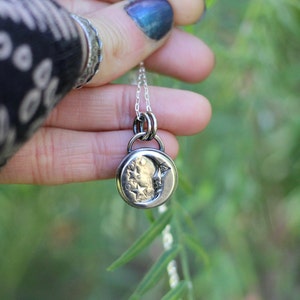 Puede incluir: Un collar de plata con un dije de luna creciente con un dise&ntilde;o de estrella. El dije cuelga de una cadena de plata.