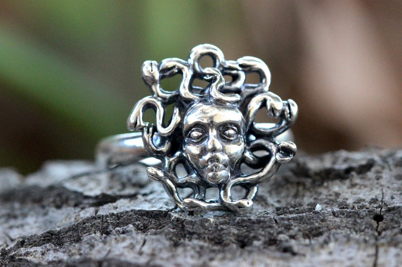 Puede incluir: Un anillo de plata con un dise&ntilde;o detallado de la cabeza de Medusa rodeada de serpientes.