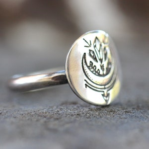 May include: A silver ring with a crescent moon and a crystal design. The ring is made of sterling silver and is a great gift for anyone who loves celestial jewelry.