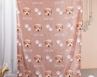 May include: A dusty rose blanket featuring a repeating pattern of a dog's face, paw prints, and the name "BARTON" in white. The blanket is made of a soft material and is suitable for home decor.