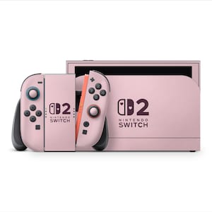 May include: A pink Nintendo Switch console and controllers. The console and controllers are a solid pink colour with black buttons and accents. The text "Nintendo Switch" is printed on the console and controllers.