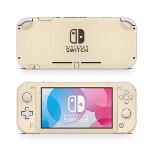 Puede incluir: Una consola Nintendo Switch Lite de color crema, mostrada desde la parte delantera y trasera. La vista frontal muestra una pantalla con un gráfico colorido. La parte trasera presenta el logotipo de Nintendo Switch. La consola tiene controles integrados.